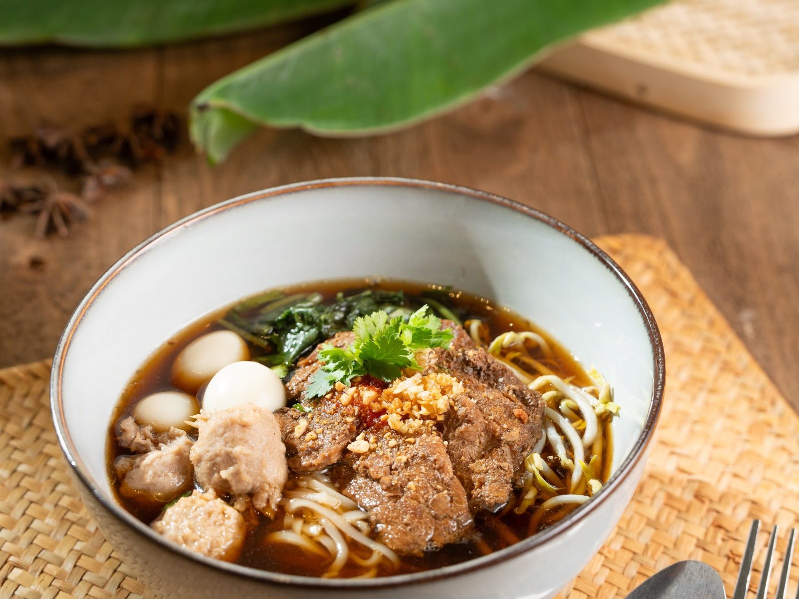 Boat Noodle Phisek Beef: rice noodles in dark beef broth with sliced beef, meatballs and egg