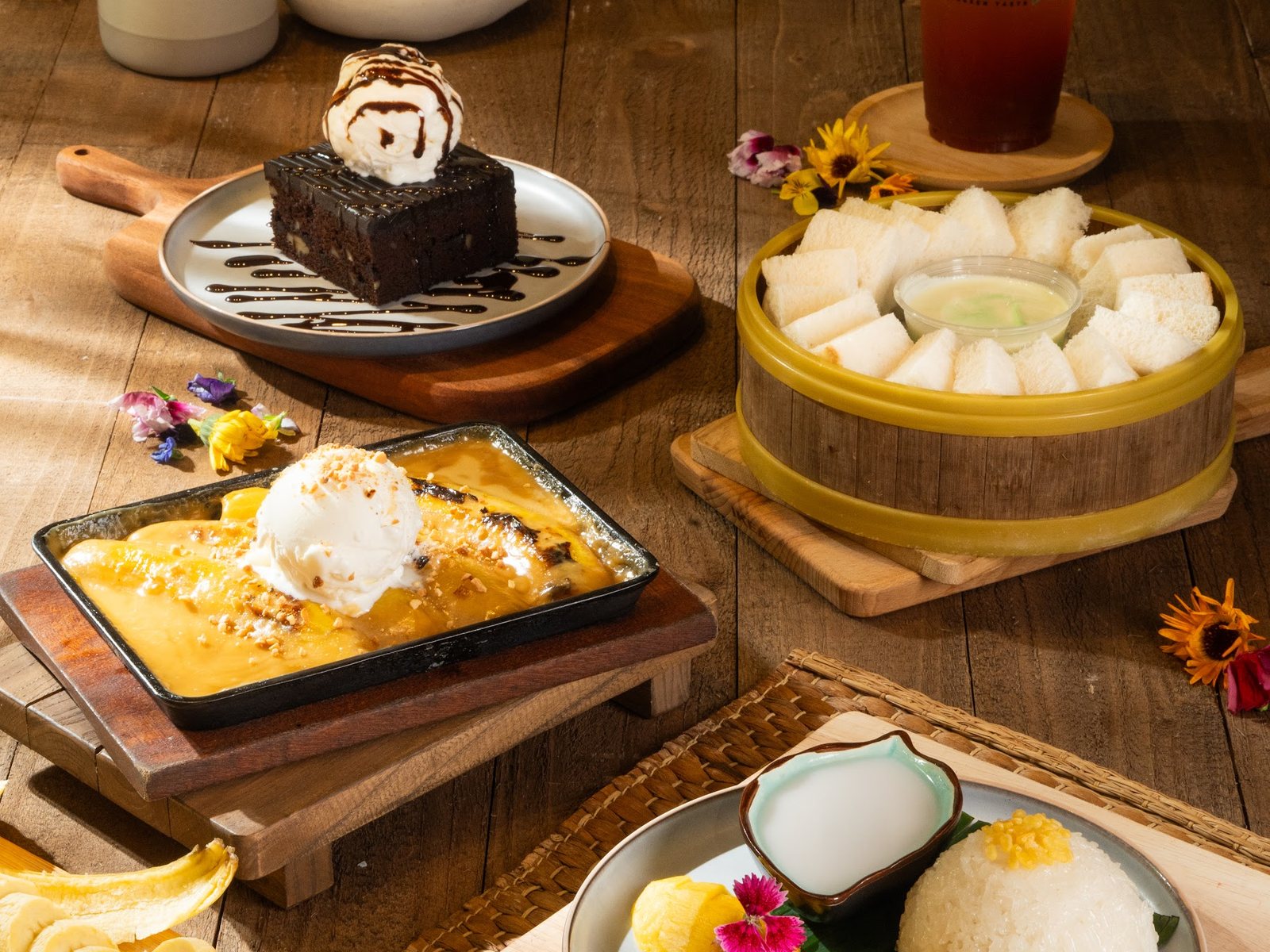 Banana caramel on a sizzling plate, mango sticky rice and chocolate brownie
