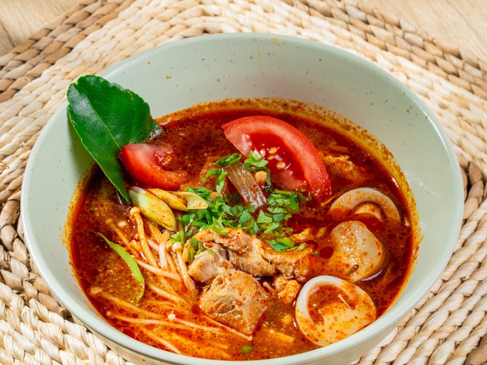 Chicken tomyum soup noodles, red broth with tomato and lime